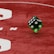 Two green dice with rounded edges are positioned on a red surface that seems to be part of a game board. The surface has white text and numbers on it, including the word 'LUCKYTOPSPIN' in capital letters.